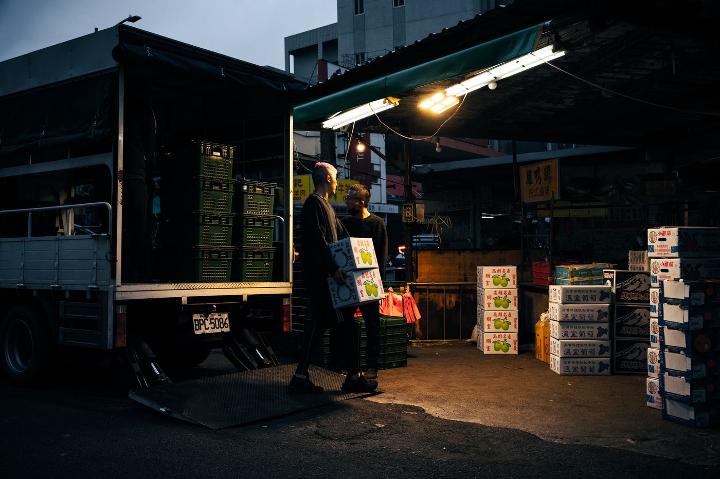 Workers unloading a lorry at a loading bay at night