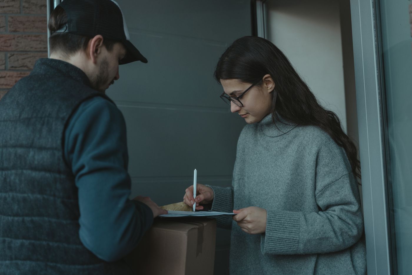 A customer signing for a parcel at the door